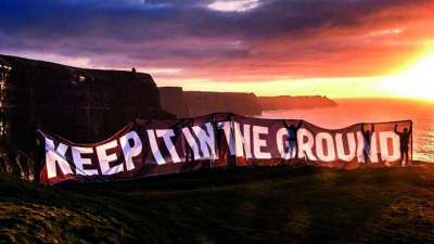 image: keep it in the ground protest banner with sunset