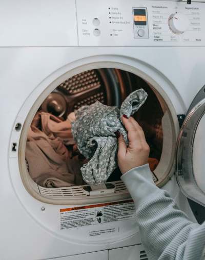 Person putting clothes in washing machine