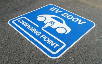 Blue painted EV 200v charging point sign on the road