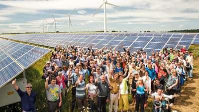 Crowd of people standing by solar panels