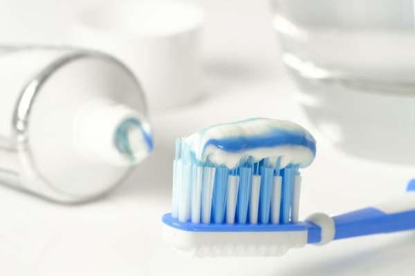 Image: blue and white toothpaste on blue and white toothbrush