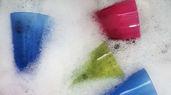 Multi coloured glasses in washing up bowl