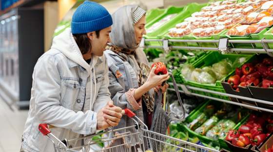Couple shopping for food with trolley and fresh produce
