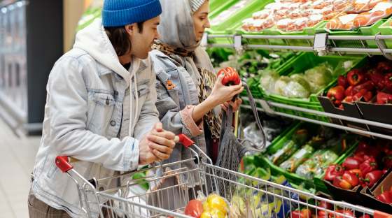 Couple shopping for food with trolley and fresh produce
