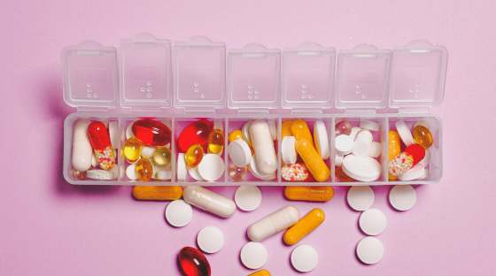 Box with seven compartments filled with vitamins and pills