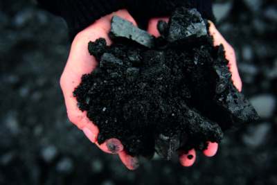 image: pink hands holding black coal