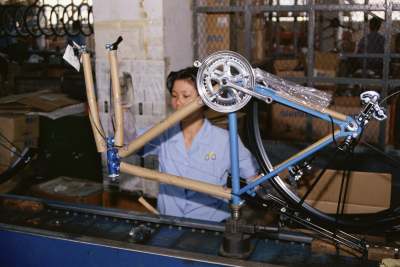 Woman making a bike in factory