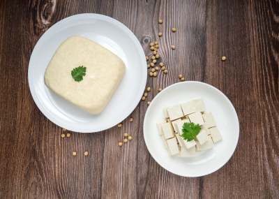 Plate of block of tofu, and dish with cubed tofu
