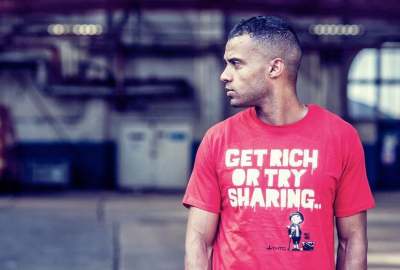 Man wearing red t-shirt with logo 'get rich or try sharing'