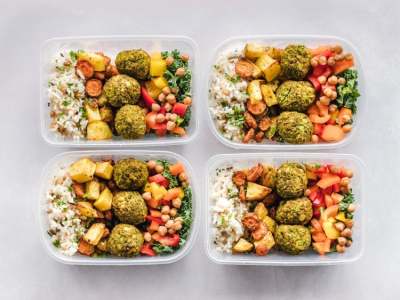 four boxes of vegetarian and vegan food including rice, falafel and vegetables