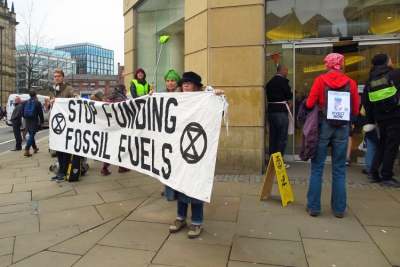 Protestors holding banner 'Stop funding fossil fuel's in front of Barclays Bank building