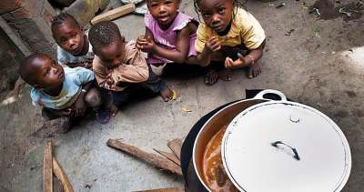 Children sitting around a cookstove in Guinea