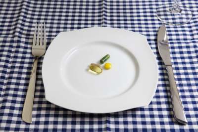 Dinner plate with vitamins and supplements in middle