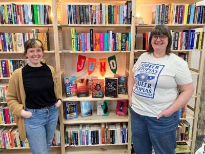 Two women standing infront of bookshelves