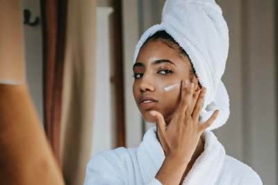 Woman putting moisturiser on face
