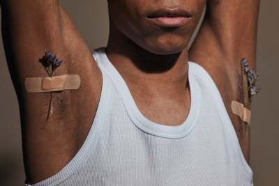 Person with armpits showing with sprig of lavender taped to the armpit