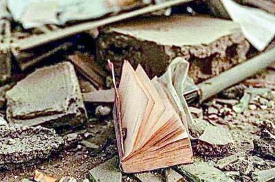 Book lying on ground amid rubble