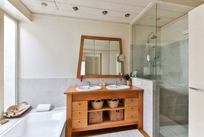 Bathroom with white bath and tiled shower and wooden sink unit