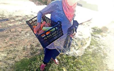 Woman carrying vegetables in a crate