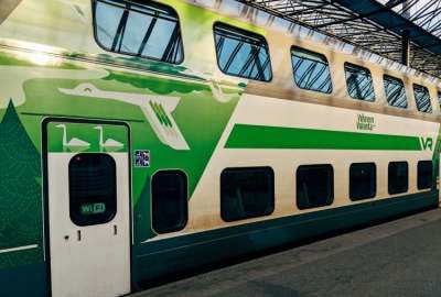 Green and white double decker train in station