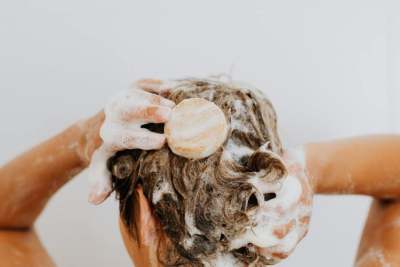 Person washing hair with shampoo bar