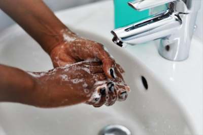 Person washing hands in sink