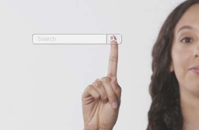 Photo with half a woman's face visible, and her finger pressing the search button on a screen