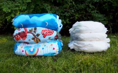 Two piles of 3 folded nappies, one pile reusables, one pile disposables