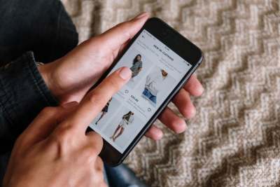 Person browsing clothes on mobile phone