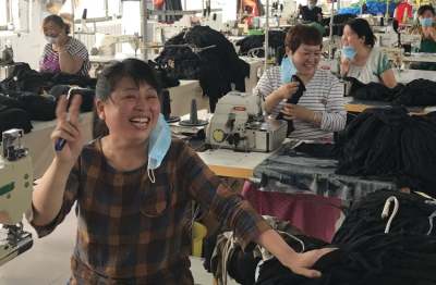 Factory with smiling garment workers at sewing machines