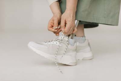 Person tying laces on trainers, with a prosthetic leg