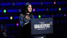 Image: Amika george young woman speaking at a podium dark background