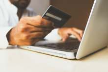 Male holding credit card and laptop buying online shopping