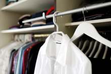 White shirt and clothes hanging up in wardrobe