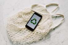 white cotton string bag with mobile phone displaying recycle logo