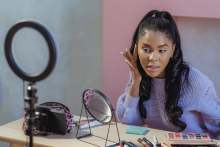 Black woman applying make up