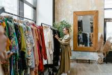 Woman browsing clothing racks in shop