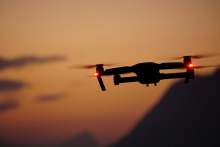 drone flying in sky with evening orange background sky