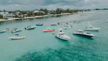 Yachts and speed boats in tropical waters with beach coastline