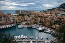 View of high rise buildings around a marina, Monaco, with sea in background