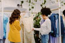Two women looking at a dress in a boutique 