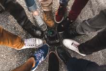 Top down view of 11 feet in different footwear standing in a circle