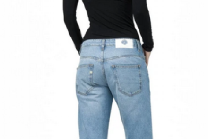 Woman standing wtih back to camera wearing blue jeans and black top