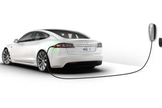 White electric Tesla car plugged in