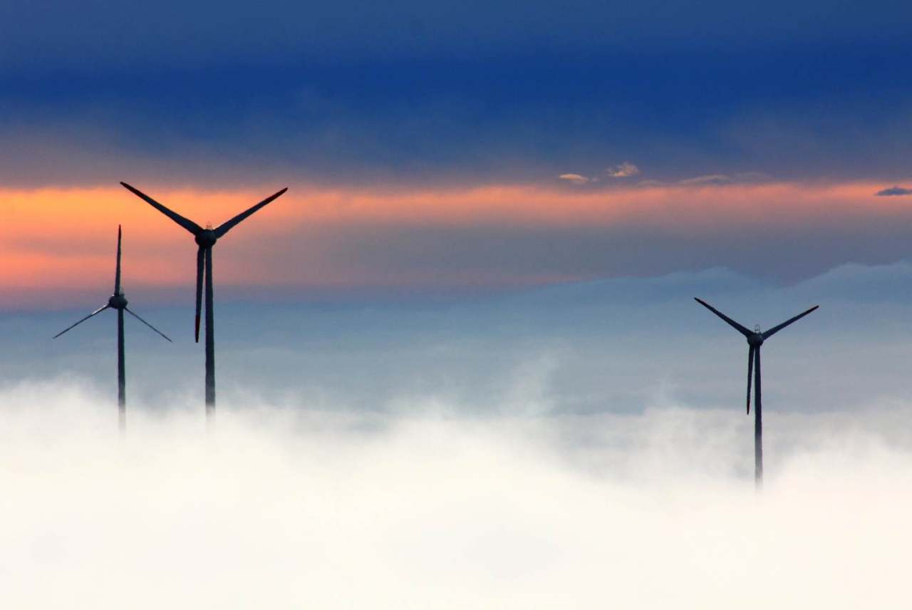 image: windmills silhouetted against a patterned sky 