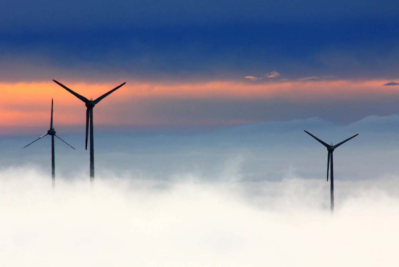 image: windmills silhouetted against a patterned sky 