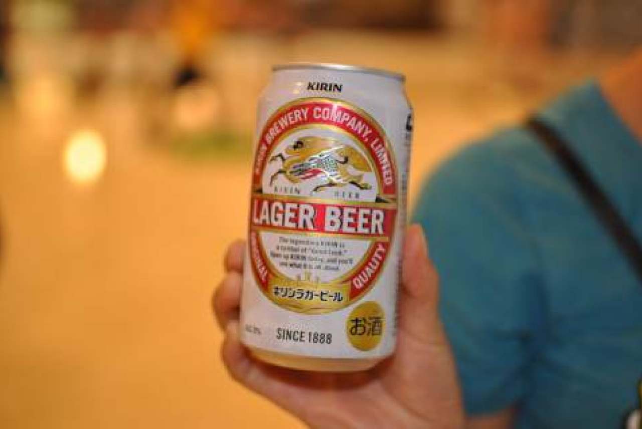 image: kirin beer can in focus in hand brooklyn lager donations burmese military