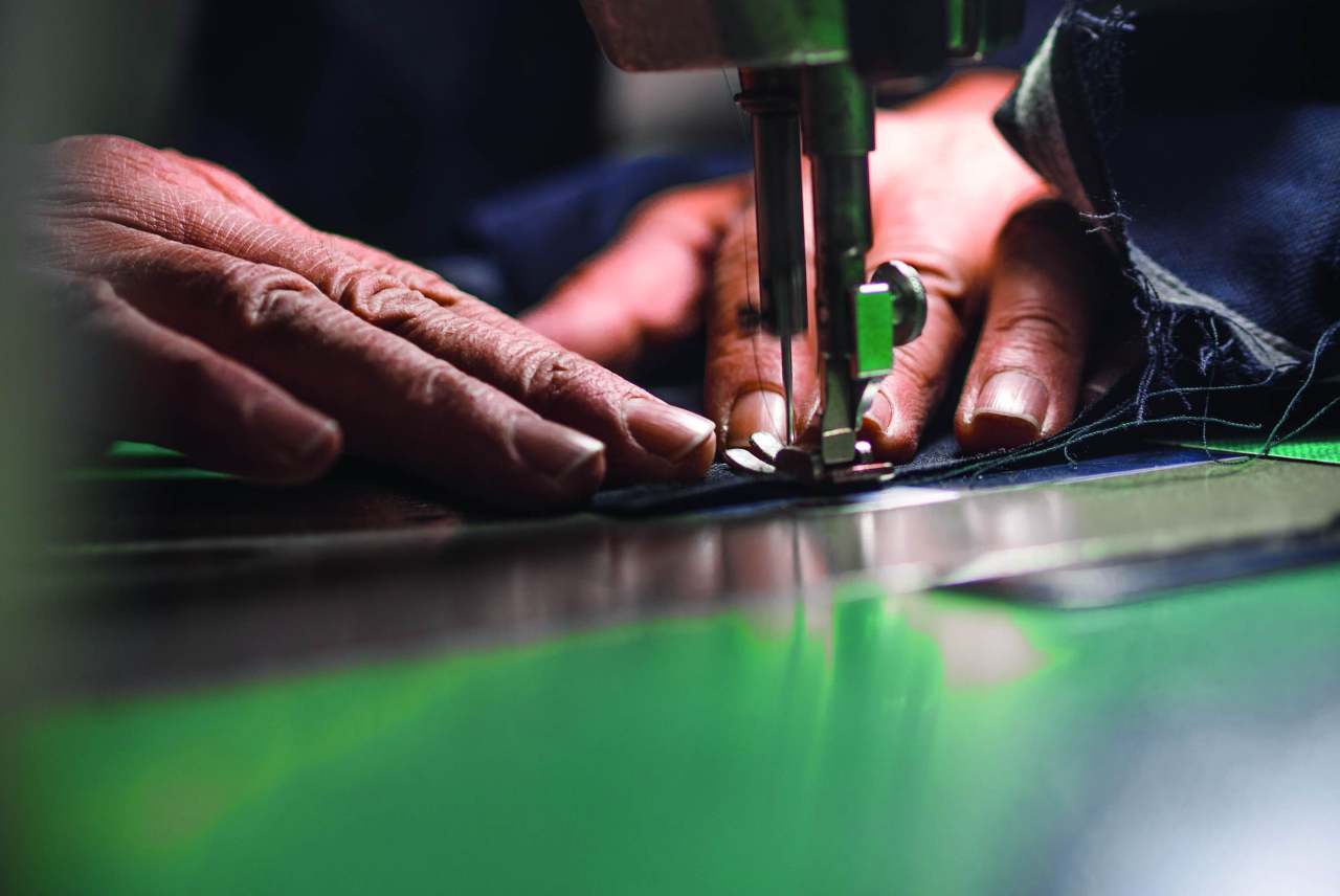 image: fashion workers hands using a sewing machine