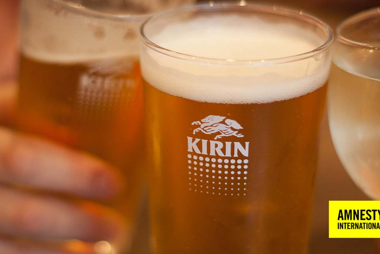 image: kirin beer can in focus in hand brooklyn lager donations burmese military