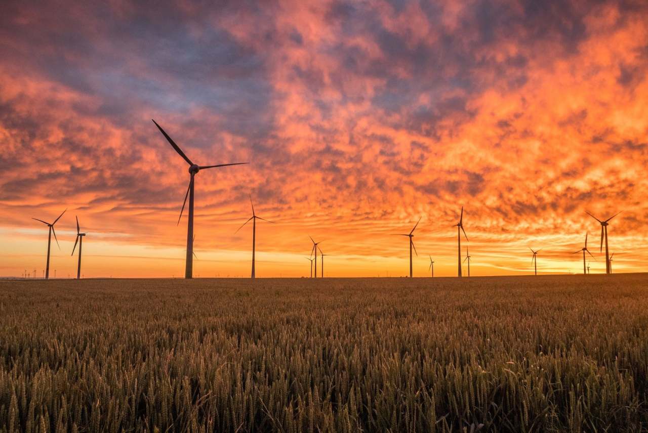 image: windmills against orange clouds sunset